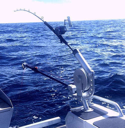 Boat-mounted downrigger deployed for offshore trolling